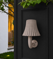 Modern grey LED outdoor wall light with textured fabric-style shade mounted on a dark exterior wall