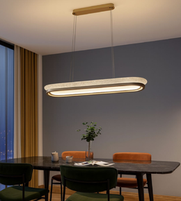 Orbita Linear Pendant with marble-inspired oval frame hanging above a modern dining table.