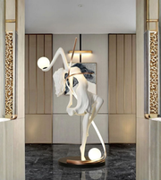 Illuminated dancer sculpture floor lamp with glowing spheres in a luxury modern interior at entrance
