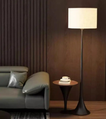Modern fabric shade floor lamp beside sofa creating warm ambient lighting in cozy living room interior