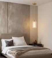 Modern glass bedside pendant with warm ambient lighting.