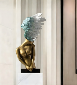 Decorative winged human form floor sculpture with metallic gold finish and artistic feather detailing
