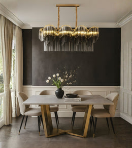 Luxe metal fringe dining chandelier with warm lighting above a modern luxury dining table interior