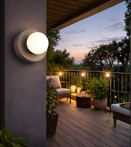 Grey indoor wall light with frosted globe illuminating modern seating area