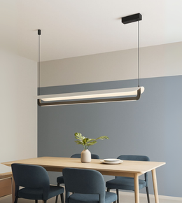 Moda Strip sleek LED pendant light in black hanging over modern dining table.
