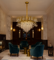 Royal Crest gold chandelier with crystal beads and drops hanging in a luxury seating area