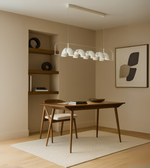 Arcus Linear Pendant Light with dome diffusers suspended above a dining table