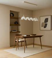 Arcus Linear Pendant Light with dome diffusers suspended above a dining table