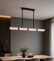 Modern black 4-light linear LED pendant chandelier with rectangular diffusers suspended above a luxury dining table in a contemporary dining room.