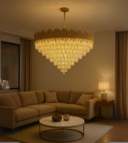 Golden Pyramid chandelier with tiered glass design illuminating a luxurious living room with warm golden tones.