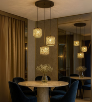 Aurelis Glow gold crystal pendant light shining warmly in modern dining setup.