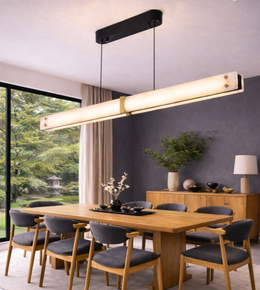 Modern marble-effect linear LED pendant light with gold accents and black suspension above a contemporary wooden dining table.
