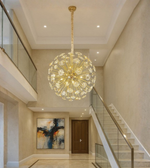 Solis Orb gold chandelier resembling sunburst design in a modern home