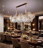 Crystal leaf luxury dining chandelier with warm lighting installed in a fine dining restaurant interior