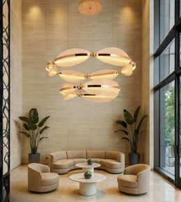 Orbital Grand Chandelier glowing above a modern lounge with beige interiors.
