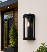 Modern black metal and glass outdoor wall light with decorative E27 bulb mounted on an exterior wall