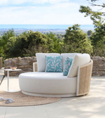 Daya Worldwide Hommy outdoor daybed set with plush cushions, surrounded by greenery, perfect for relaxing outdoor lounging.