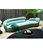 Daya Worldwide Aura Curve Sofa with sleek modern design, plush cushions, and smooth curves in a contemporary living room setting.