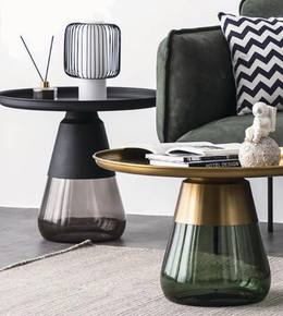 Elegant glass side table with clear tabletop and sleek metal legs, ideal for modern living spaces.