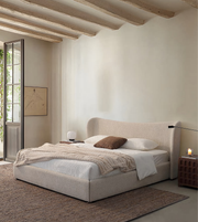 Modern minimalist bedroom with light upholstered bed, cozy bedding, and warm neutral decor