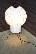 Close-up of ribbed paper lantern lamp shade with warm glow