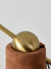 Detail view of brass joint and textured tan base of floor lamp