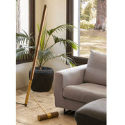 Wooden leaning floor lamp styled near window and indoor plant