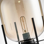 Detail view of black metal stand and glass dome shade
