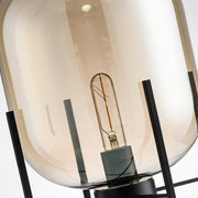 Detail view of black metal stand and glass dome shade