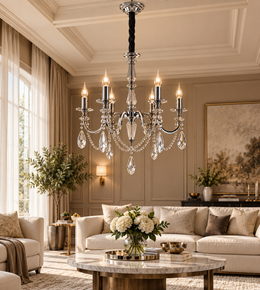 Luxury chrome crystal chandelier with candle-style lights and teardrop pendants in an elegant beige living room.