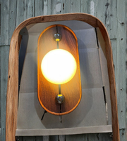 Close-up of wooden wall sconce with spherical diffuser