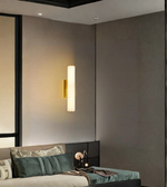 Vertical marble wall sconce with brass mount in modern bedroom