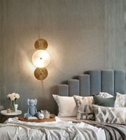 Decorative wall sconce in a bedroom with a bed and pillows.