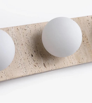 Close-up of stone-finish wall light with round glass globes