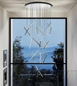 Modern chandelier hanging in a room with a large window view of trees and mountains.