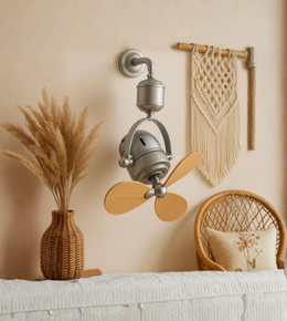 Decorative wall-mounted fan with wooden blades in a room with a vase of pampas grass and a woven chair.