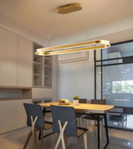 Dining room with a modern pendant light fixture above a table and chairs.