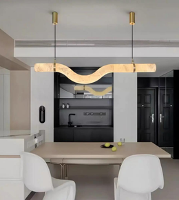Modern dining area with a wavy pendant light fixture.