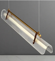 Modern pendant light with clear罩and gold fixture on a gray background