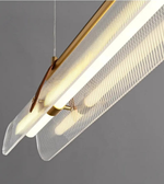 Modern pendant light with gold fixture and clear mesh shade on a gray background