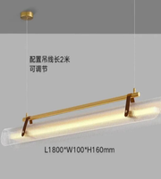 Modern pendant light with gold fixture on a gray background