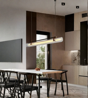 Modern kitchen with a long pendant light fixture above a dining table.