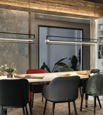 Modern dining room with a long table and chairs, featuring a large window in the background.