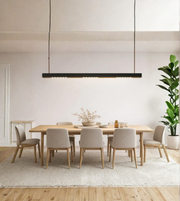 Dining room with wooden table and chairs, potted plant, and pendant light.