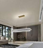 Modern chandelier hanging in a stylish bedroom with large windows and decor.