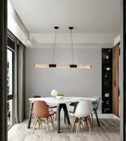 Modern dining area with a white table and colorful chairs against a gray wall.