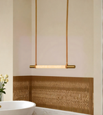 Modern pendant light fixture in a bathroom setting with a decorative wall panel.