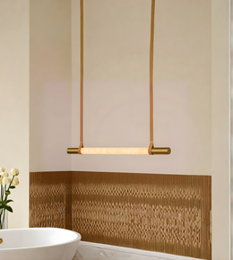 Modern pendant light fixture in a bathroom setting with a decorative wall panel.