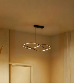 Modern pendant light hanging from a ceiling in a softly lit room.