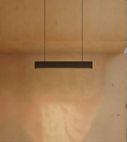 Modern pendant light hanging against a wooden wall